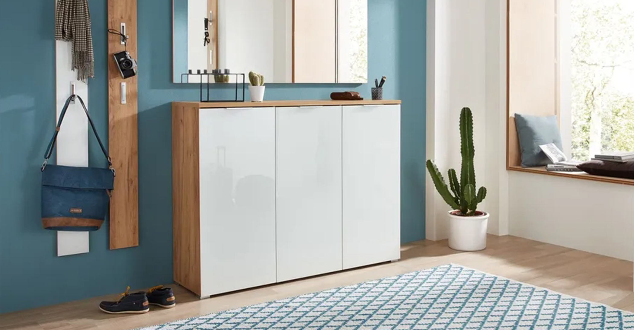 Garderobenschrank mit Hochglanz-Fronten in Weiß und Korpusse aus Holz mit schmalen Griffen.